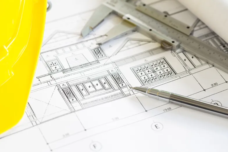 construction-plans-with-yellow-helmet-drawing-tools-bluep